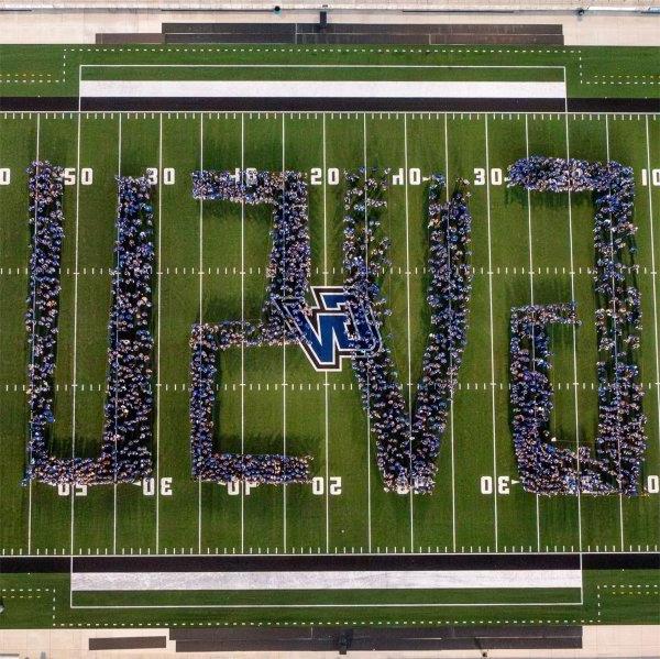 incoming students stand on football field, creating 博天堂官方 for a drone photo